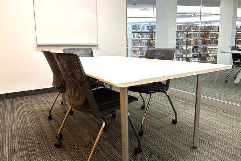 Photograph of small study room with a table, four chairs, and a whiteboard