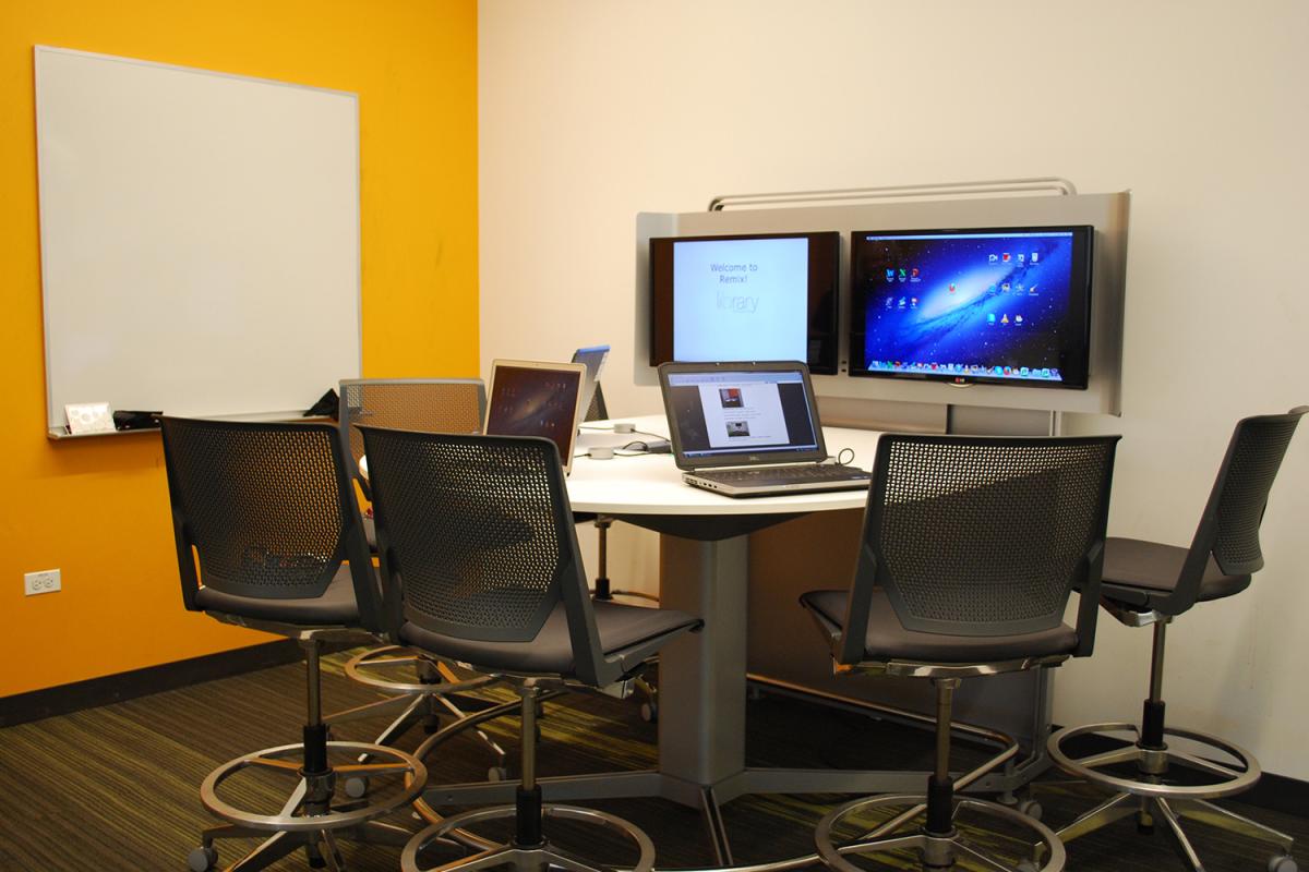 Bar room interior shot with laptops, whiteboard, and mounted monitors