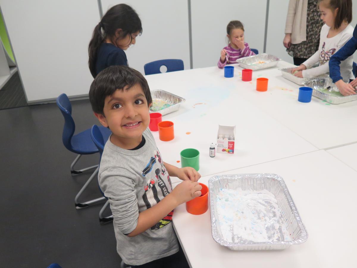 A boy smiles while working on a science project